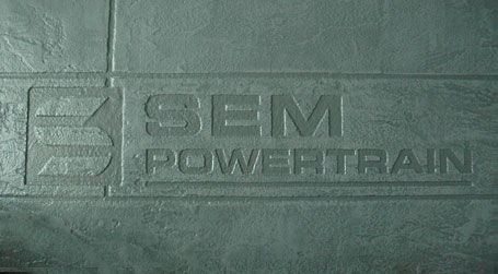 Image of the SEM Powertrain logo embossed in concrete - at our facility in Pickering, Ontario, Canada.